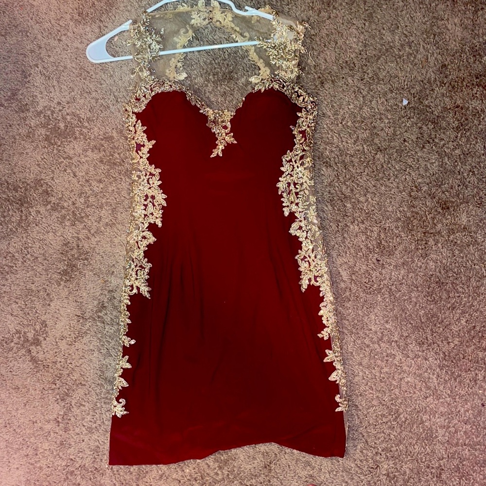 It’s a Maroon dress with gold lace and colourful crystals down the side.